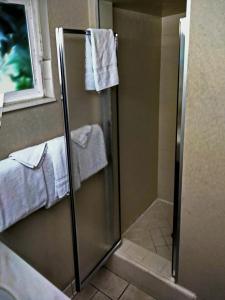 a bathroom with a shower with towels hanging on the wall at Metropolitan Inn Downtown Salt Lake City in Salt Lake City