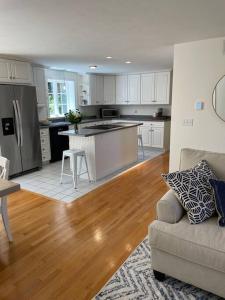 eine Küche und ein Wohnzimmer mit einem Sofa und einem Tisch in der Unterkunft 56Beachway-Private beach Refreshed in 2022 Cozy in East Sandwich