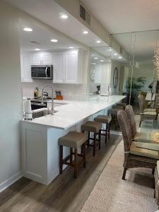 a kitchen with a large white counter and chairs at Newly Remodeled Hilton Head Villa in Hilton Head Island