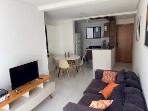 sala de estar con sofá, TV y mesa en Suas férias boa à Bessa, en João Pessoa