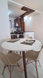 una mesa de comedor blanca con sillas en la cocina en Suas férias boa à Bessa, en João Pessoa