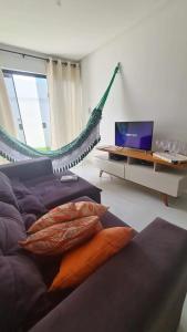 1 dormitorio con cama y mesa con ordenador portátil en Suas férias boa à Bessa, en João Pessoa