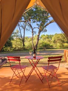 two chairs and a table with wine glasses on it at Wildhaven Sonoma Glamping in Healdsburg