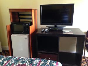a room with a desk with a television and a microwave at Flamingo Inn in Seaside Heights