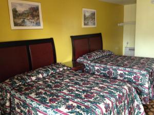 two beds sitting next to each other in a hotel room at Flamingo Inn in Seaside Heights