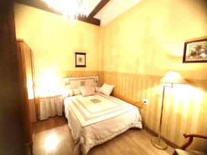 Un dormitorio con una cama y una lámpara. en Encantadora casa de pueblo en Sagunto