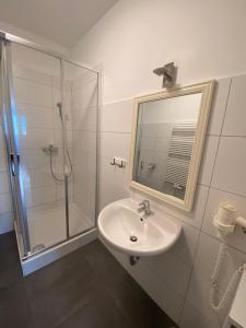 a bathroom with a sink and a shower with a mirror at Lungau Living Appartements - Penthouse in Sankt Michael im Lungau