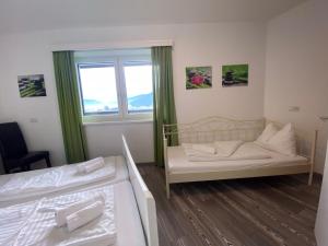 a small room with two beds and a window at Lungau Living Appartements - Penthouse in Sankt Michael im Lungau
