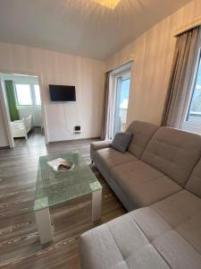 ein Wohnzimmer mit einem Sofa und einem Tisch in der Unterkunft Lungau Living Appartements - Penthouse in Sankt Michael im Lungau