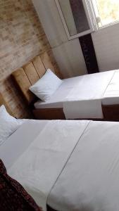 two beds sitting in a room with a window at FamilyConfort Saidia in Saïdia