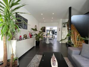 a living room with a couch and some plants at Modern 1BR house near Heysel, Expo, Palais 12, Atomium, UZVUB et stade Roi Baudouin in Wemmel