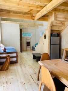 Zimmer mit einer Küche, einem Tisch und einem Kühlschrank in der Unterkunft Travesía austral tinyhouse in Puerto Varas