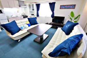 a living room with a white couch and blue pillows at Hana house - Vacation STAY 92529v in Ginowan