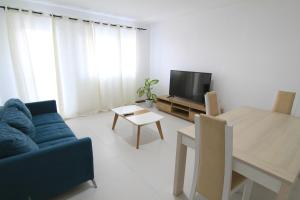 ein Wohnzimmer mit einem blauen Sofa und einem Tisch in der Unterkunft Quick Stay in Praia #2 in Praia