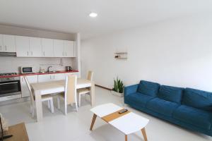 ein Wohnzimmer mit einem blauen Sofa und einem Tisch in der Unterkunft Quick Stay in Praia #2 in Praia