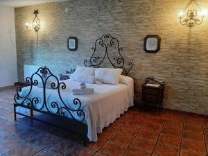 a bedroom with a bed and a brick wall at Vivienda Turística El Acebuchal in Ubrique