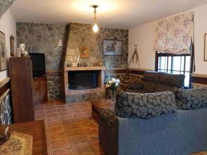 sala de estar con sofá y chimenea en Vivienda Turística El Acebuchal, en Ubrique