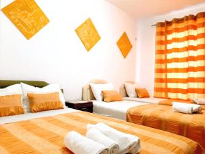 two beds in a room with orange and white at Villa Alba Apartments in Dobra Voda