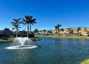 a fountain in the middle of a pond with palm trees at Beachside, 5 Bedroom Exclusive Home in Indian Harbour Beach