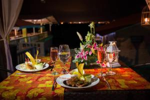 a table with two plates of food and wine glasses at Hotel San Antonio del Cerro in Pereira +98 photos