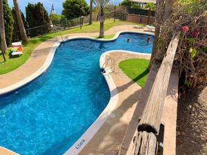 una piscina con un banco en un parque en Adosado con piscina a 5 minutos de la playa en Almuñécar
