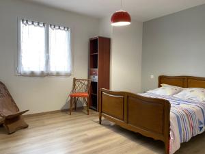 een slaapkamer met een bed en een stoel erin bij Maison de Campagne in Brignac-la-Plaine