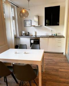 una cucina con tavolo e sedie bianchi di EXKLUSIVES Loft an der Weserpromenade und Stadt a Brema
