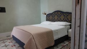 a bedroom with a bed with a headboard at Baglio Sant’Angelo in Licata