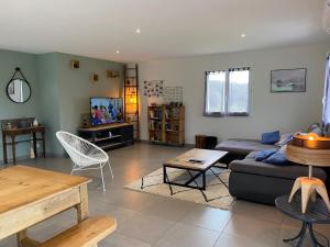 a living room with a couch and a table at Maison de Campagne in Brignac-la-Plaine