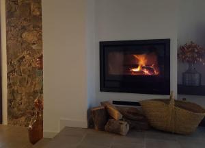 sala de estar con chimenea en la pared en El corralet del Lloar, vistes infinites al Priorat, en Lloá