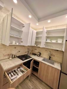 una cocina con armarios blancos y fregadero en Wonder Hill group, en Bakuriani