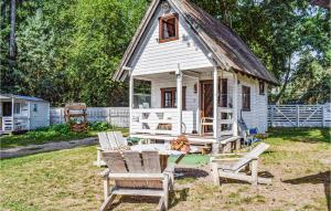a small white house with chairs and a table at 1 Bedroom Beautiful Home In Pobierowo in Pobierowo