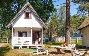a small white house with a picnic table and a bench at 1 Bedroom Beautiful Home In Pobierowo in Pobierowo