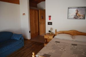 1 dormitorio con 1 cama y 1 sofá azul en B&B Nido Delle Aquile, en Monclassico