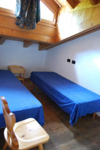 Cette chambre dispose de deux lits, d'une chaise et d'une fenêtre. dans l'établissement B&B Nido Delle Aquile, à Monclassico