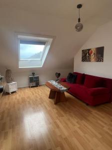 a living room with a red couch and a window at Ferienwohnung Mosel in Niederfell