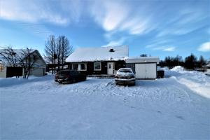 zwei Autos im Schnee vor einem Haus geparkt in der Unterkunft RIBO Apartment Arctic in Kiruna