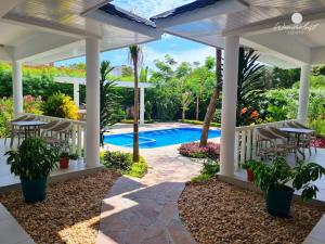 un patio trasero con piscina y pérgola en Fiorella Beach House, Diani Beach en Diani Beach