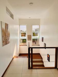 un pasillo con escaleras y ventanas en una casa en Fiorella Beach House, Diani Beach, en Diani Beach