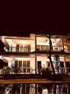 un gran edificio blanco con un árbol delante en Fiorella Beach House, Diani Beach, en Diani Beach