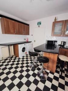 a kitchen with a black and white checkered floor at Old Trafford City Centre Events 4 Bedrooms 6 rooms sleeps 3 - 8 in Manchester
