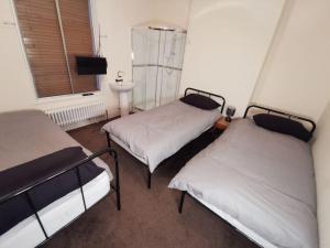 a room with two beds and a sink and a window at Old Trafford City Centre Events 4 Bedrooms 6 rooms sleeps 3 - 8 in Manchester