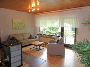 a living room with a couch and a table at Idyllic Bungalow in Feusdorf with by the Forest in Feusdorf