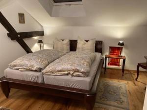 a bedroom with a large bed with pillows at Dorfstübchen in Hohen Neuendorf