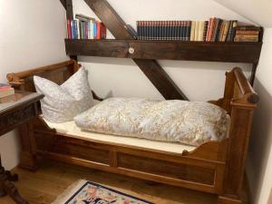ein Bett in einem Zimmer mit Bücherregal in der Unterkunft Romantische Ferienwohnung im Grünen in Hohen Neuendorf