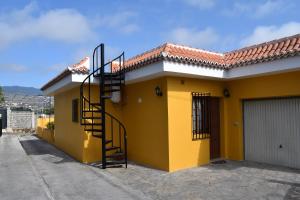 a yellow house with a spiral staircase on it at CASA FLORENTINA in Los Llanos de Aridane