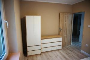 Pokój z białą szafką i szafą w obiekcie Pokoje gościnne w mieście Stradunia
