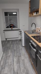 une cuisine avec un plancher en bois et une fenêtre dans l'établissement estrella24 LIVING ROOMS Chicago, à Remscheid