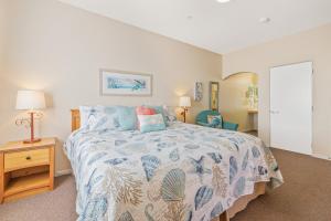 a bedroom with a bed with a blue and white bedspread at Pacific Plaza Resort Unit 108 in Oceano