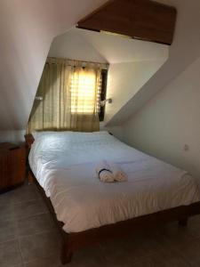 1 dormitorio con 1 cama con 2 zapatillas en אירוח גאלה בגולן, en Katzrin